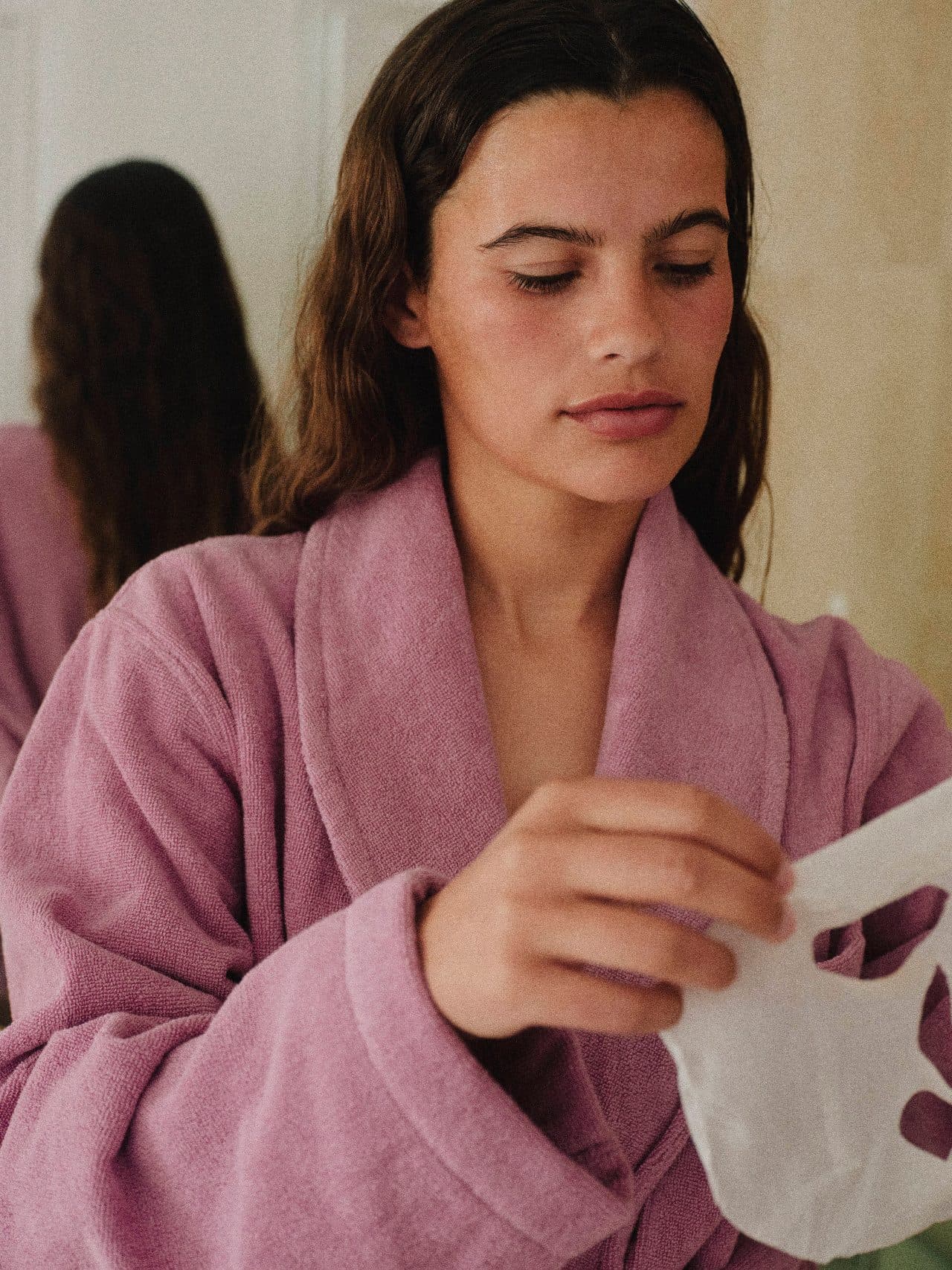 A model with pink blush holding a swallowtail butterfly